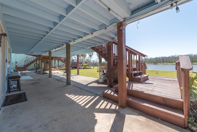 view of patio / terrace with stairway and a deck with water view