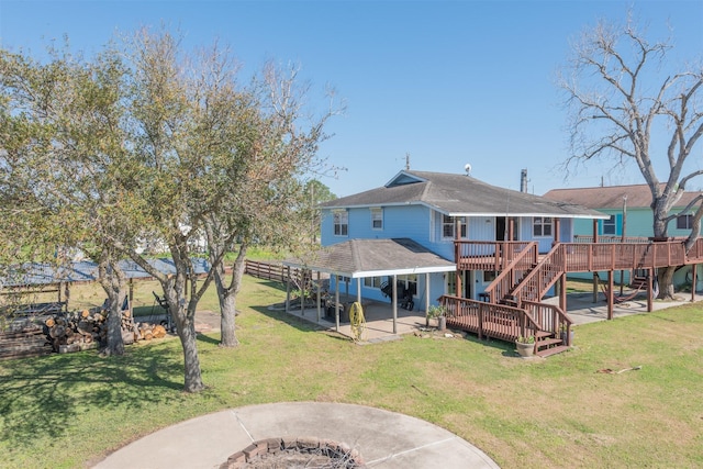 back of house featuring a deck, a patio, a lawn, and fence