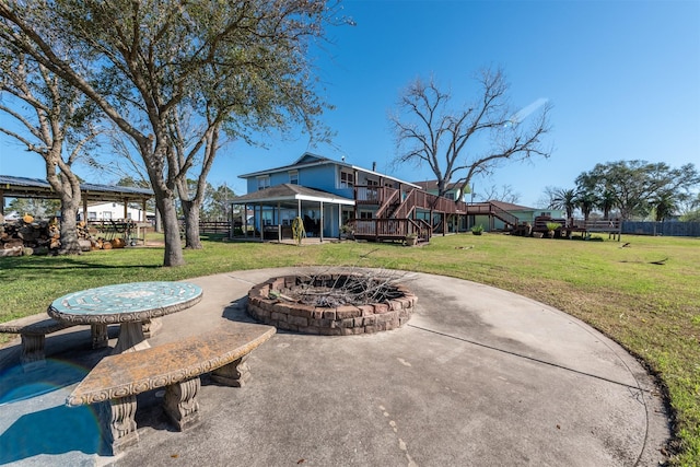 view of patio / terrace with a wooden deck, stairway, fence, and an outdoor fire pit