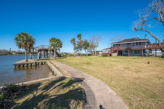 view of yard with stairway and a deck with water view