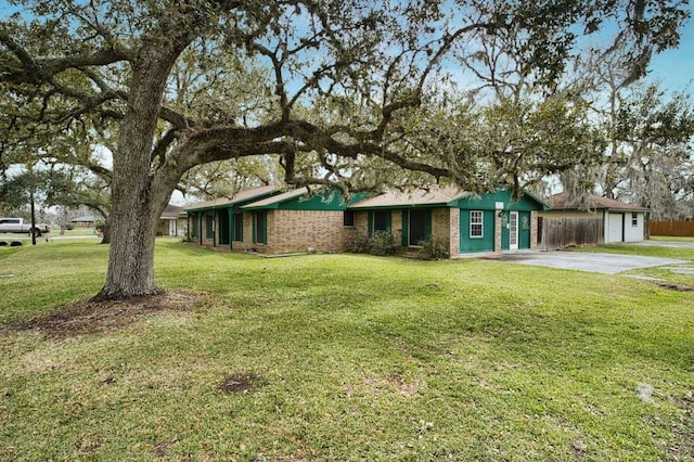 view of front of property with driveway, brick siding, and a front yard