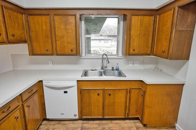 kitchen featuring a sink, dishwasher, brown cabinetry, and light countertops