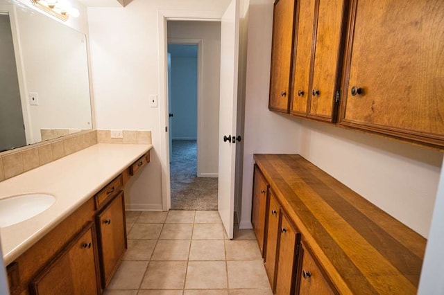 bathroom featuring tile patterned floors, baseboards, and vanity