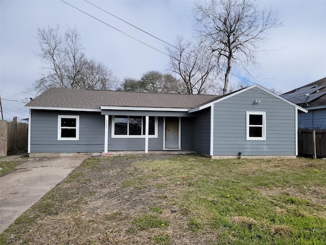 single story home with a front lawn, fence, and roof with shingles