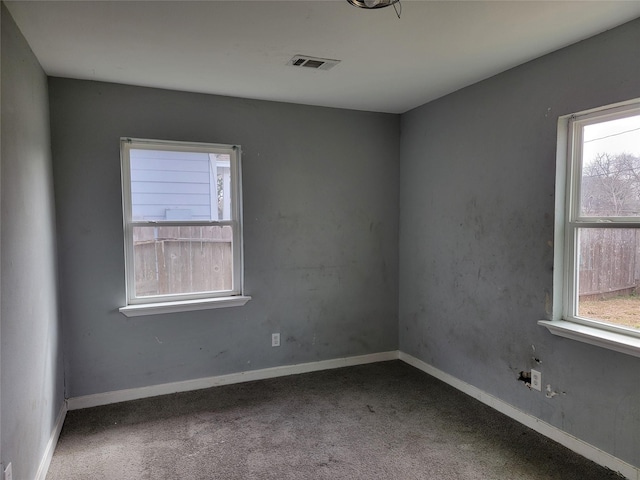 carpeted spare room featuring baseboards and visible vents