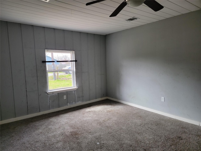 empty room with carpet flooring, baseboards, visible vents, and ceiling fan