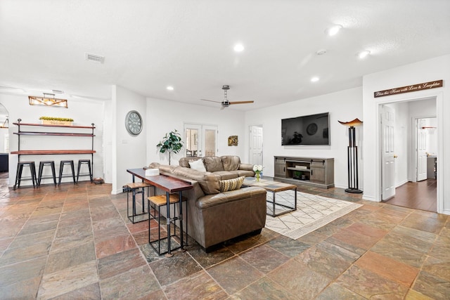 living room with visible vents, a ceiling fan, stone tile flooring, and recessed lighting