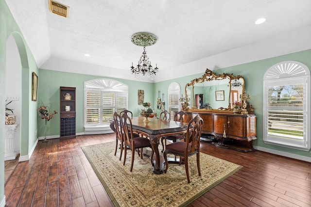 dining area with hardwood / wood-style flooring, baseboards, a wealth of natural light, and a notable chandelier