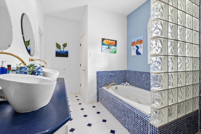 full bathroom featuring baseboards, tile patterned floors, a sink, and a whirlpool tub