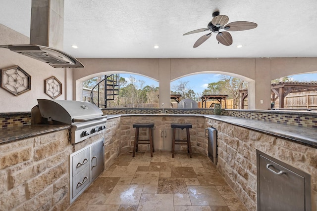 view of patio featuring grilling area, a ceiling fan, an outdoor kitchen, and a sink