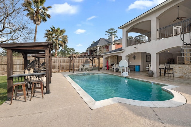 view of swimming pool with a patio area, a fenced backyard, outdoor dry bar, and ceiling fan