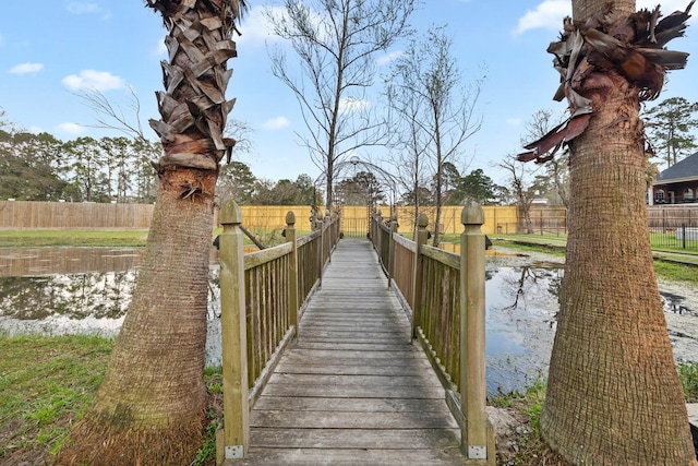 dock area featuring fence and a water view