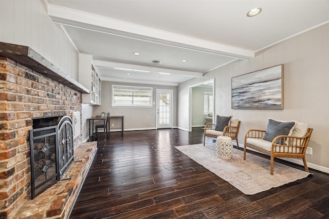 interior space with baseboards, beam ceiling, wood finished floors, and a fireplace