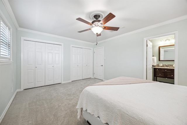 carpeted bedroom with crown molding, baseboards, and multiple closets