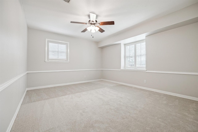 carpeted empty room with ceiling fan and baseboards