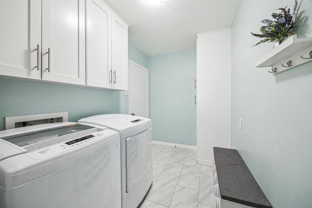 clothes washing area featuring baseboards, cabinet space, marble finish floor, and washing machine and dryer