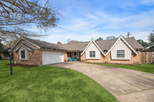 view of front of house featuring a front yard, driveway, a chimney, a garage, and brick siding