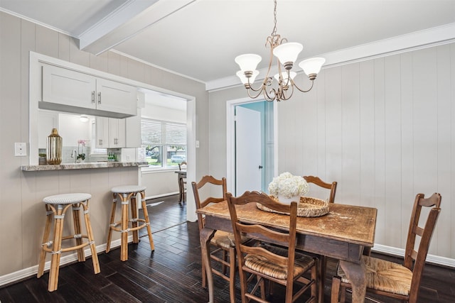 dining space featuring dark wood-type flooring, baseboards, a chandelier, and ornamental molding