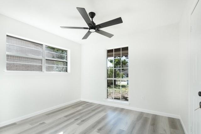 spare room with ceiling fan, baseboards, and wood finished floors