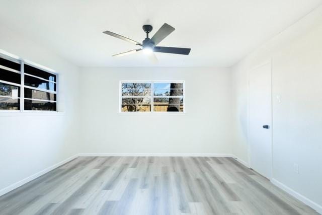 unfurnished room featuring a ceiling fan, wood finished floors, and baseboards