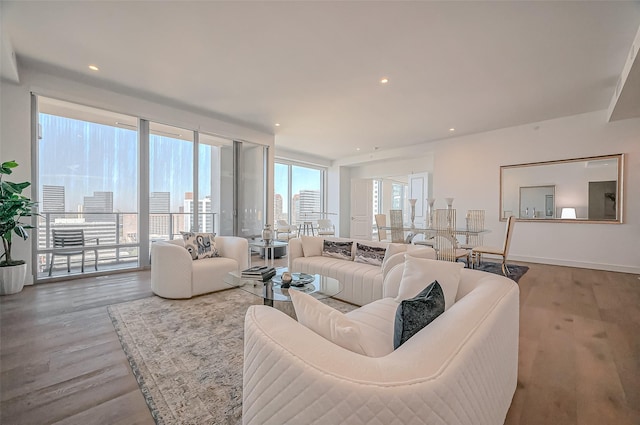 living room featuring a city view, recessed lighting, baseboards, and wood finished floors