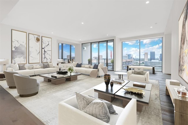 living area with wood finished floors, recessed lighting, a wall of windows, and a city view