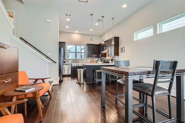 kitchen featuring stainless steel appliances, tasteful backsplash, visible vents, and dark wood finished floors