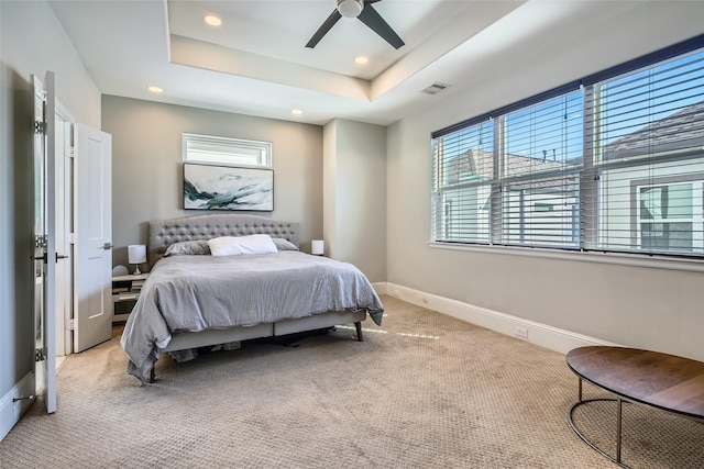 bedroom featuring baseboards, visible vents, recessed lighting, light carpet, and a raised ceiling