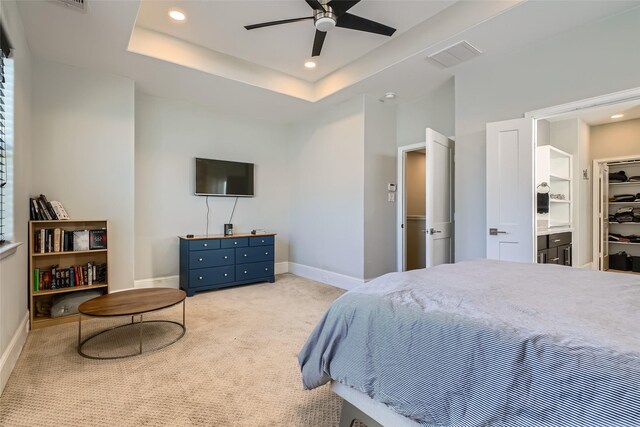 bedroom with baseboards, visible vents, a tray ceiling, recessed lighting, and carpet flooring