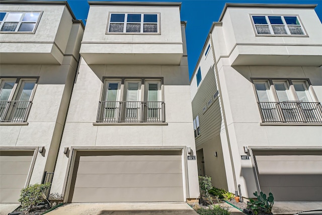 view of property featuring stucco siding, a garage, and concrete driveway