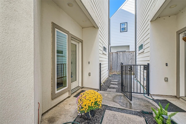 entrance to property with fence and stucco siding