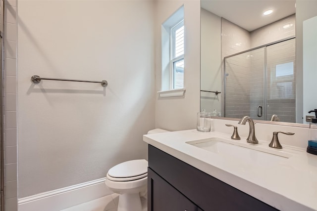 bathroom with vanity, toilet, and a stall shower