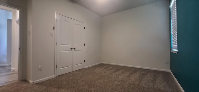 spare room featuring carpet and baseboards