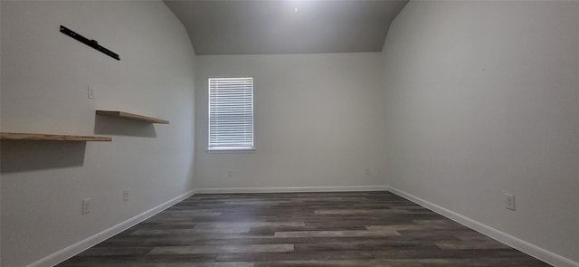 unfurnished room featuring baseboards, dark wood-type flooring, and lofted ceiling