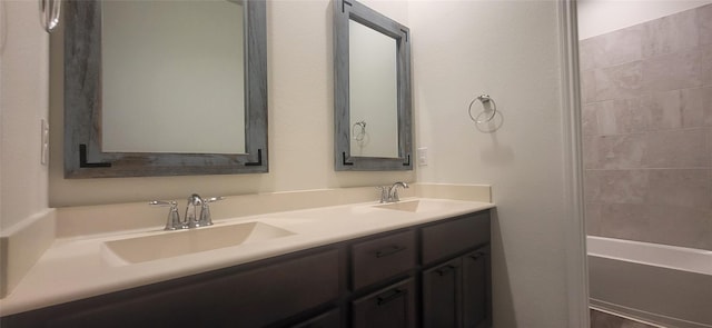 full bathroom featuring double vanity, tub / shower combination, and a sink