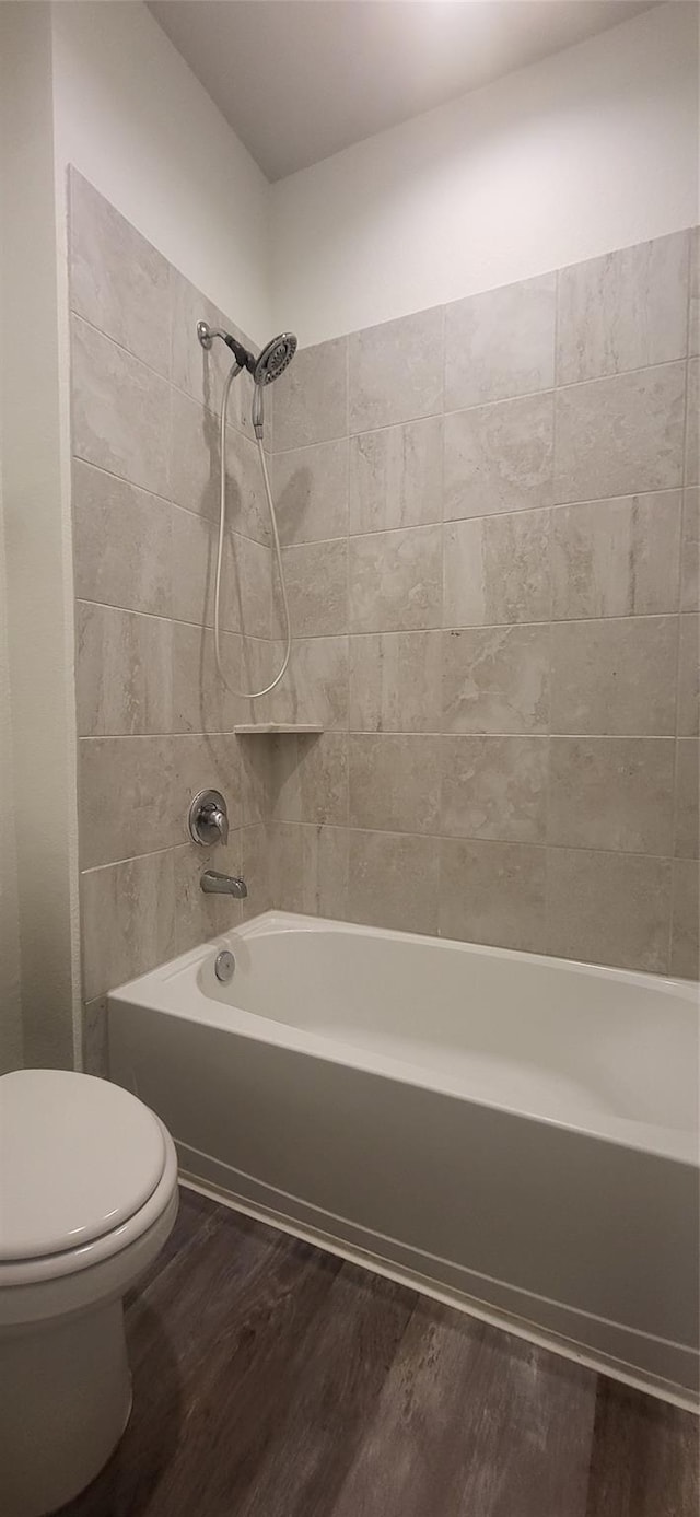 full bathroom featuring shower / washtub combination, toilet, and wood finished floors