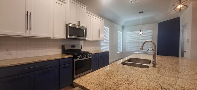 kitchen with a sink, stainless steel appliances, decorative backsplash, and white cabinetry