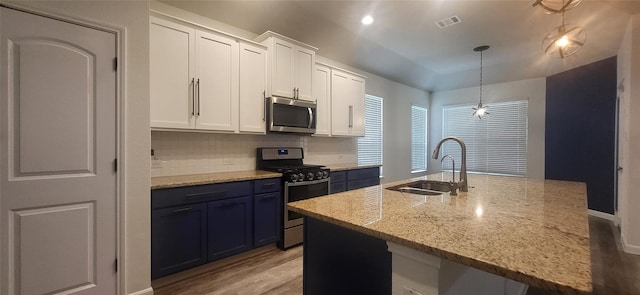 kitchen featuring tasteful backsplash, visible vents, white cabinets, stainless steel appliances, and a sink