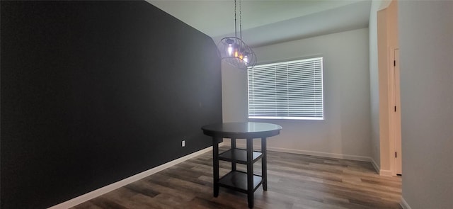 dining room featuring dark wood-type flooring, baseboards, and vaulted ceiling