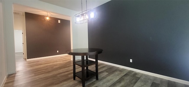 dining space with vaulted ceiling, visible vents, baseboards, and wood finished floors