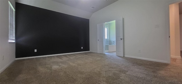 spare room with visible vents, baseboards, lofted ceiling, and carpet floors