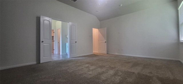 carpeted spare room with baseboards and lofted ceiling