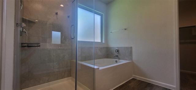 full bath with a shower stall, baseboards, a garden tub, and wood finished floors