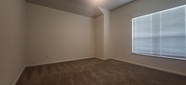 carpeted empty room featuring baseboards