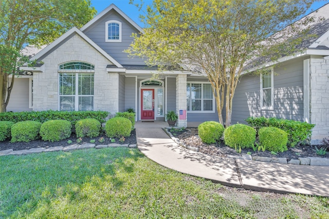291 Berkley Dr, Montgomery, TX 77356 - traditional home with stone siding, a front yard, and covered porch
