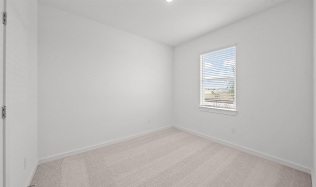 carpeted spare room featuring baseboards