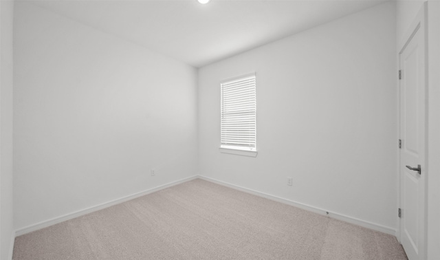 carpeted empty room featuring baseboards