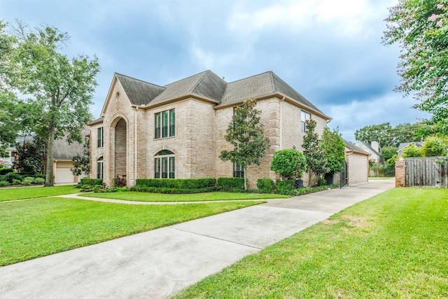 french country inspired facade with fence, brick siding, a front lawn, and a shingled roof