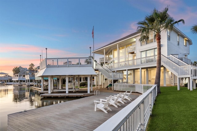 dock area with a water view and a lawn