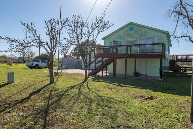 view of front facade with a front lawn, stairway, and a wooden deck